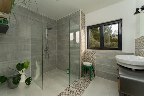 uma casa de banho com um chuveiro e um lavatório. em Casa do Vale Cabo em Olival
