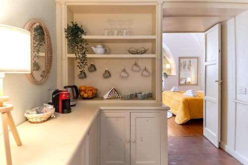 een keuken met witte kasten en een kamer met een bed bij Sikelia Luxury home in Catania