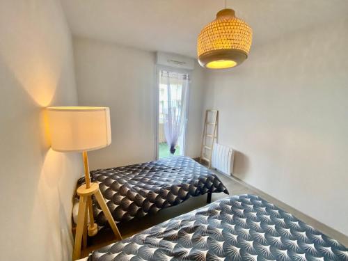 une chambre avec un lit, une lampe et une fenêtre dans l'établissement La Coquille: bright, cozy, 3 min from Parc Expo, à Poitiers