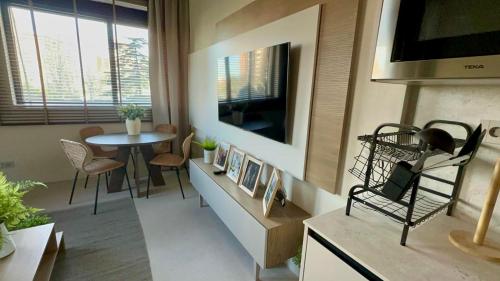 a living room with a table and a television at ARTURO SORIA Apartamento de LUJO a estrenar in Madrid