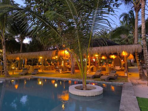 a resort with a pool and chairs and palm trees at U Story Resort in Siquijor