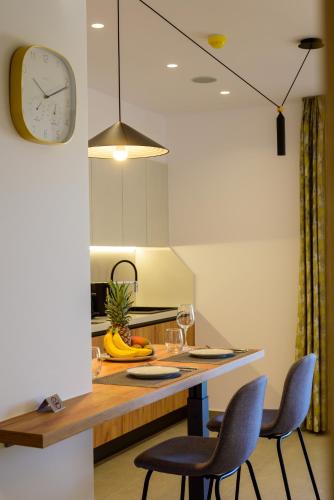 a kitchen with a table with two chairs and a clock at Antheon Apartment 1 in Agios Nikolaos