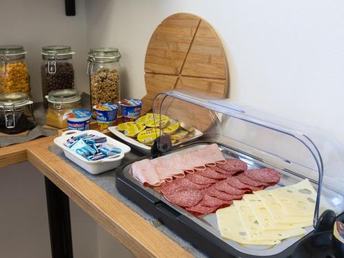 a counter with meats and cheese and other foods at Penzion Krumlovské rozcestí in Český Krumlov