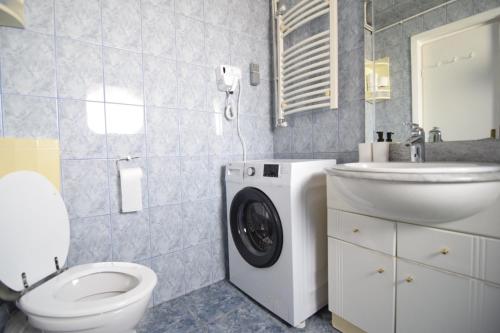 a bathroom with a toilet a sink and a washing machine at Eminescu 36 in Bucharest