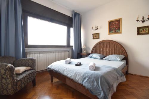 a bedroom with a bed and a chair and a window at Eminescu 36 in Bucharest
