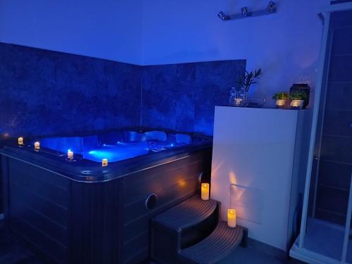 niebieska wanna z stołkiem w łazience w obiekcie Le Sablon - Hébergement bien-être, Spa & massages à 20mn de Reims centre w mieście Unchair