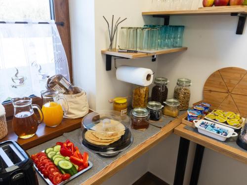 a kitchen counter with fruits and vegetables on a table at Penzion Krumlovské rozcestí in Český Krumlov