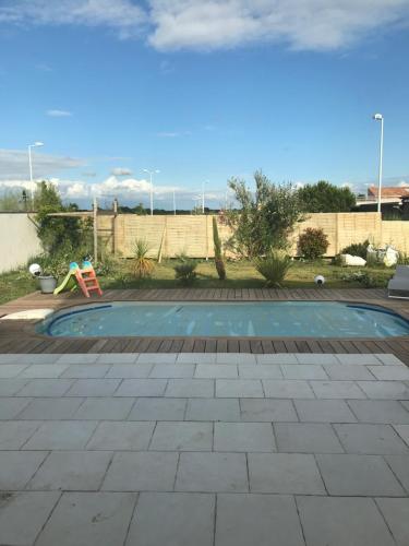 - une petite piscine avec une aire de jeux dans la cour dans l'établissement Maison spacieuse, à Marennes