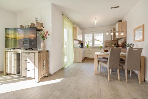 una cucina e una sala da pranzo con tavolo e sedie di Sonnenpark 02 a Korswandt