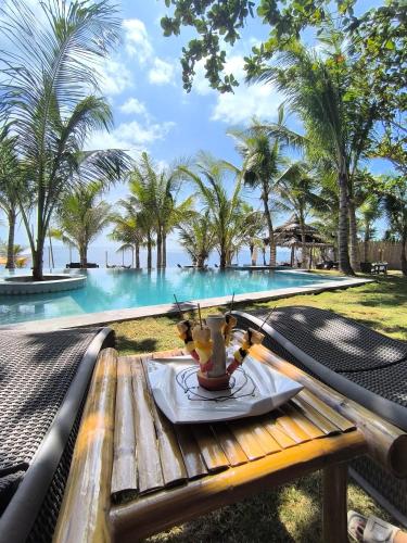 a table with a plate of food next to a swimming pool at U Story Resort in Siquijor