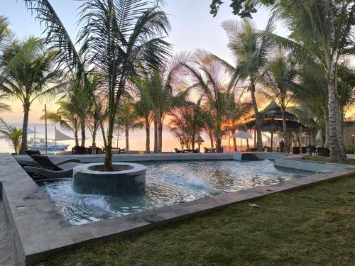 a swimming pool with palm trees in a resort at U Story Resort in Siquijor