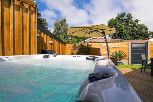 - un bain à remous avec un parasol dans l'arrière-cour dans l'établissement Appartement plage à pied, à La Teste-de-Buch