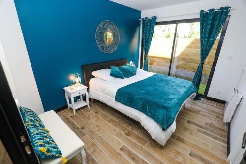 - une chambre bleue avec un lit et un mur bleu dans l'établissement Appartement plage à pied, à La Teste-de-Buch