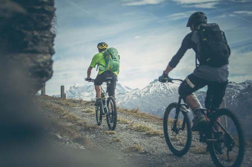 two people riding bikes on a mountain road at Hotel Brenner - Stop & Go in Vipiteno