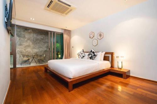 a bedroom with a white bed and a large window at EVA Beach sea view Four room villa in Ban Saiyuan (1)