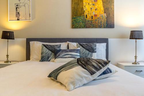 a bedroom with a bed with two pillows and a painting at Casa Inzolia in Giardini Naxos