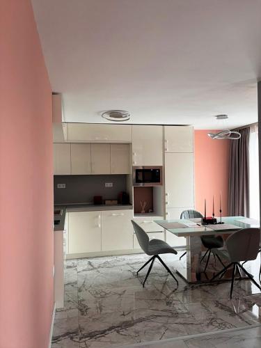 een keuken met een tafel en stoelen in een kamer bij Apartmenthaus Oborishte 5 in Panagyurishte