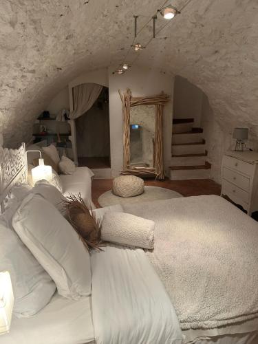 une chambre avec deux lits blancs et un miroir dans l'établissement CHARME RAMATUELLE, à Ramatuelle