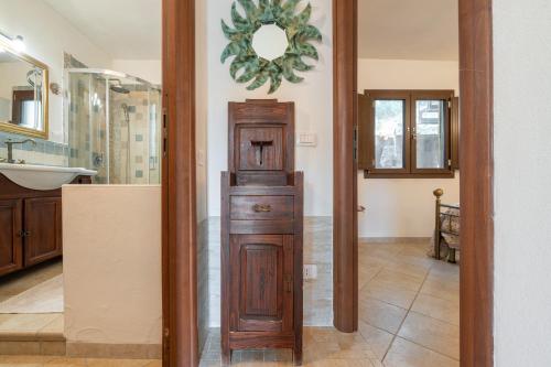 a bathroom with a tall wooden cabinet in a room at Lovely house in Santa Luria