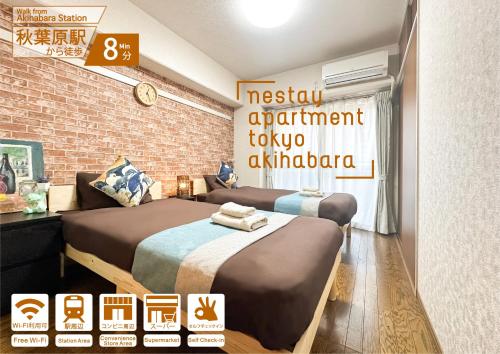 two beds in a room with a brick wall at nestay apartment tokyo akihabara in Tokyo