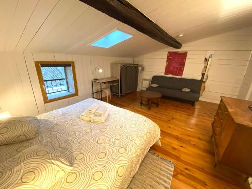 une chambre avec un lit et un canapé dans une pièce dans l'établissement Le Clain de Vivonne, cosy appartement plein centre, à Vivonne