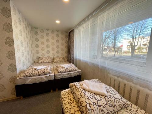 two beds in a room with a window at Savan House "Easy Kaunas" in Kaunas