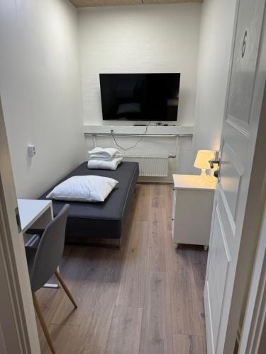 Habitación pequeña con cama y TV de pantalla plana. en Italian Rooms 6, en Aalborg
