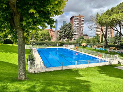 a large swimming pool in a park in a city at ARTURO SORIA Apartamento de LUJO a estrenar in Madrid