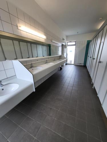 a bathroom with sinks and mirrors in a public restroom at Europe tents Camping Gritt in Diekirch