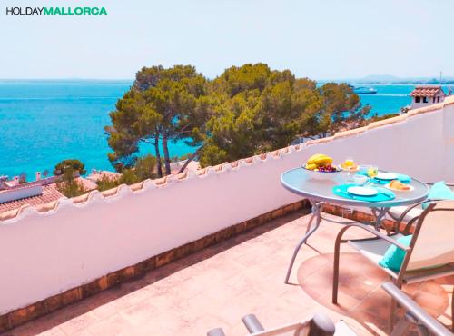 Una mesa en un balcón con vista al mar. en Aucanada Love Nest, en Alcudia