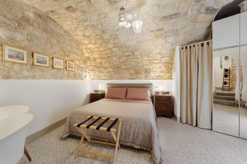 a bedroom with a bed and a stone wall at Vico Prato 1, gocce di Sicilia in Ragusa