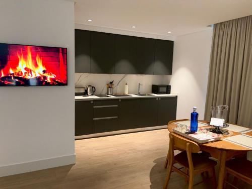 a living room with a table and a fireplace at Apartamentos Turísticos La Plaza in Chipiona