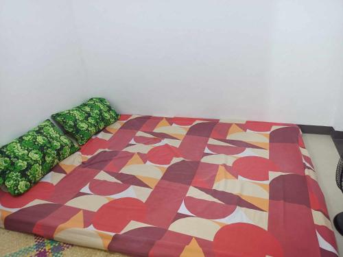 uma cama com um edredão colorido no chão em IRIGA CITY TRANSIENT HOUSE em Iriga City