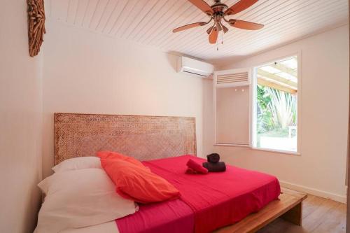 Un dormitorio con una cama roja con un osito de peluche. en Kay Azzurra en Schœlcher