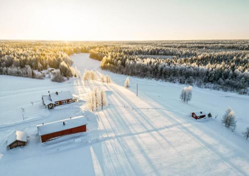 una vista aérea de un campo cubierto de nieve con camiones en Hommala, en Raiskio