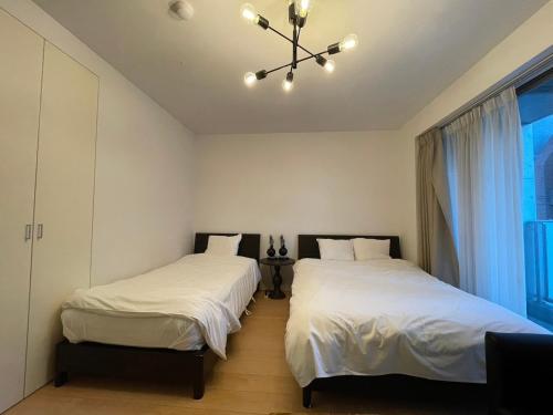 two beds in a room with a window at SALON Shibuya in Tokyo