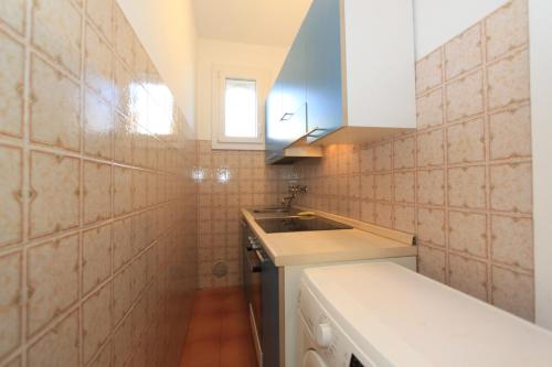 a small kitchen with a sink and a counter at Alfa Apartmerts in Lido di Pomposa