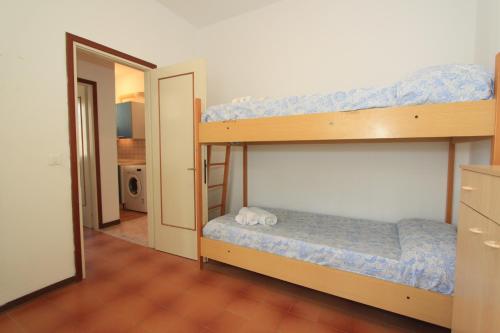 a bedroom with two bunk beds and a hallway at Alfa Apartmerts in Lido di Pomposa