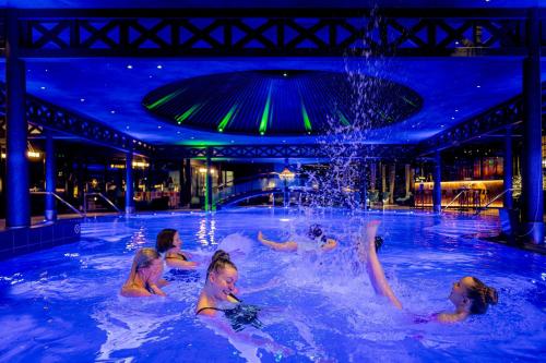a group of people swimming in a swimming pool at Break Sokos Hotel Bomba in Nurmes