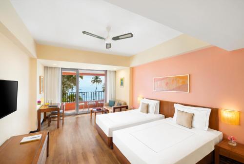 帕納吉的住宿－Taj Cidade de Goa Heritage, Goa，酒店客房设有两张床和一台平面电视。