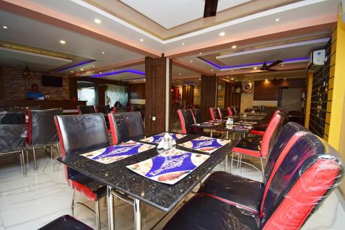 uma sala de jantar com mesas e cadeiras vermelhas em OYO Kingstar Resort em Pānāgarh