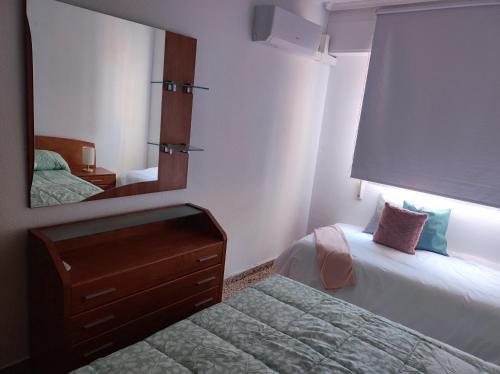 a hotel room with two beds and a mirror at Alojamiento El palmeral in Santa Pola