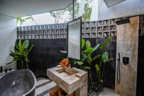 ein Bad mit einem Waschbecken und einem Spiegel in der Unterkunft 4BR Luxury Tropical Jungle Villa 4 Mins to Beach in Tanah Lot