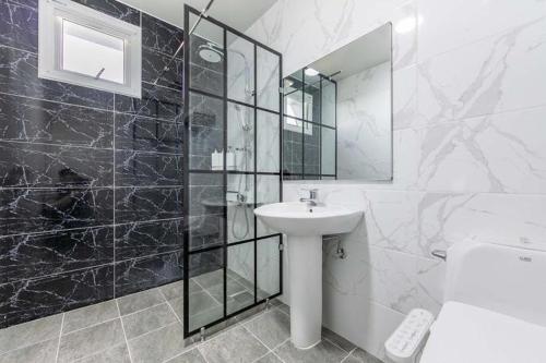 La salle de bains blanche est pourvue d'un lavabo et d'un miroir. dans l'établissement Jin Arirang Hostel, à Yeosu