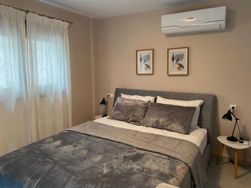 a bedroom with a bed and a air conditioner at Modern Living Experience in Néa Péramos