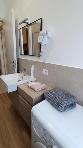 a bathroom with a sink and a toilet and a mirror at Pitagora in Pavia