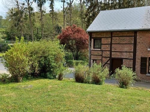 um pequeno edifício de tijolos com garagem num quintal em L'Etable de Joseph- calme et rivière em Honnay