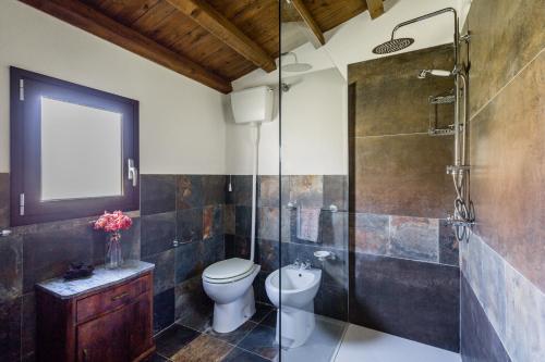 a bathroom with a toilet and a glass shower at Authentic Sicilian Charm, pool, sea view, wi-fi & parking in Avola