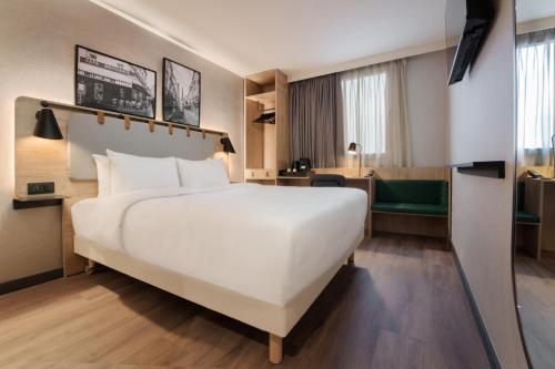 een groot wit bed in een hotelkamer bij Campanile Paris 19 - La Villette in Parijs