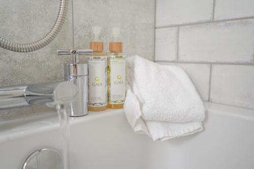 a bathroom sink with two bottles of soap and towels at Owston Hall Hotel in Doncaster